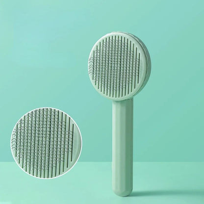Brosse pour Chat vert menthe à tête ronde, avec détail des picots métalliques.