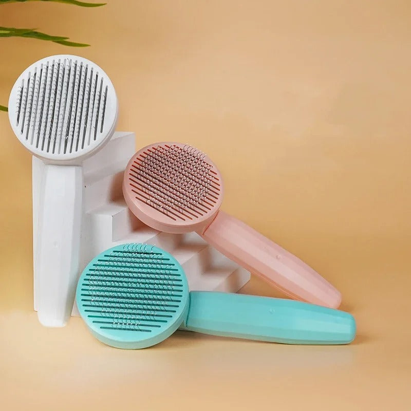 Brosse pour Chat présentée en trois coloris : blanc, rose et vert menthe.