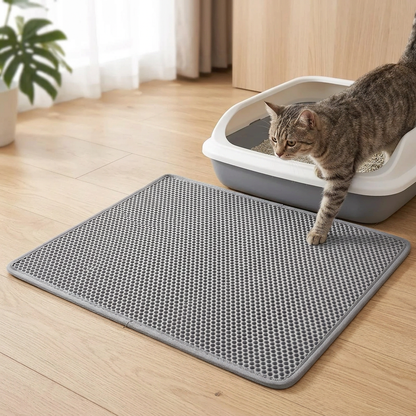 Tapis de litière chat  Chat tigré sortant de son bac à litière et posant une patte sur un tapis alvéolé gris.