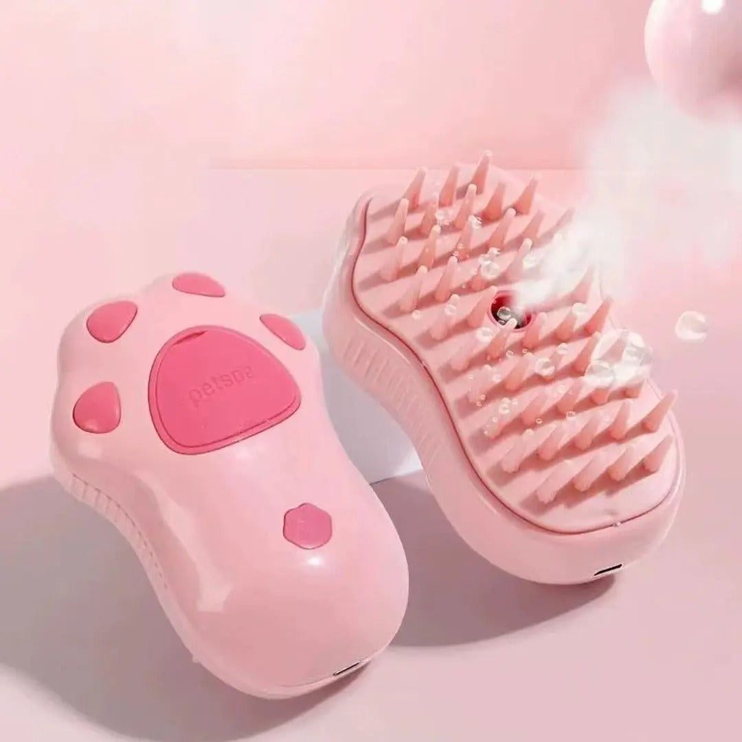 Brosse pour chat rose en forme de patte, vue de dessus et côté picots avec une brume visible.